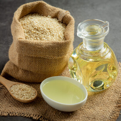 Sesame oil and sesame seeds on dark background